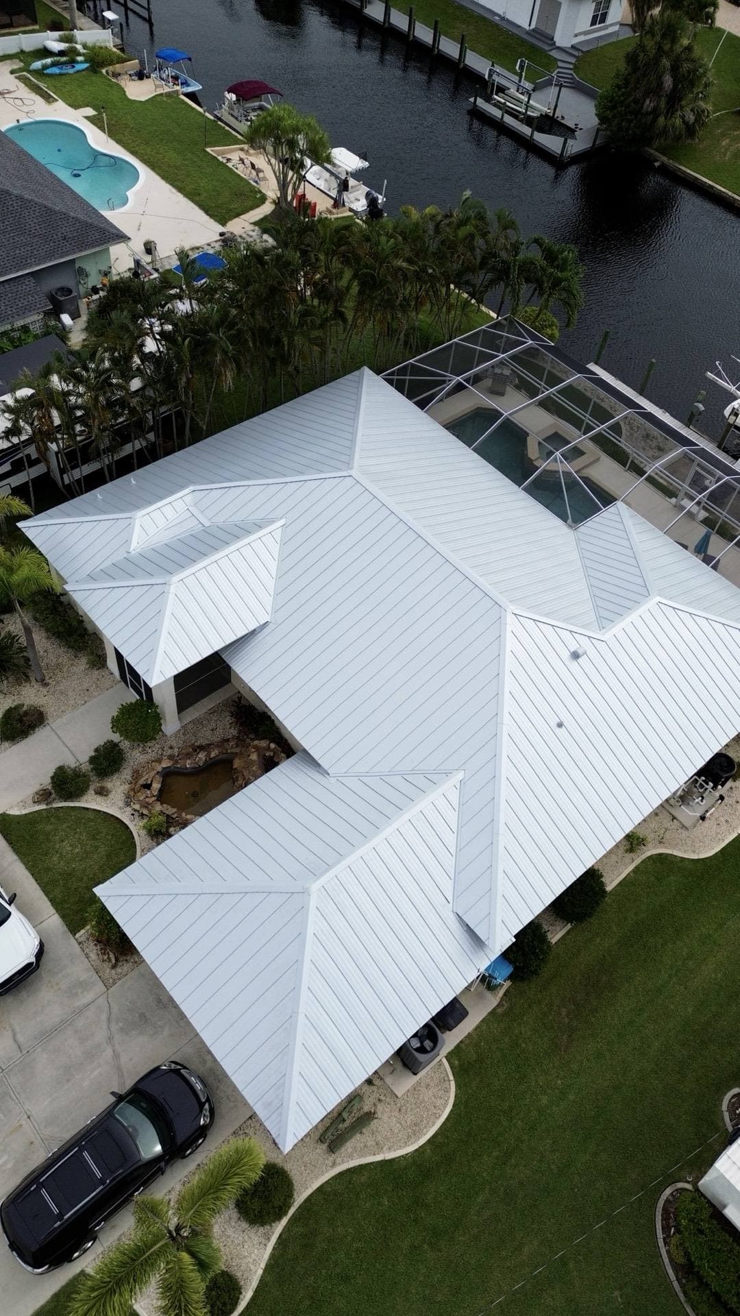 Top-down aerial view of a standing seam metal roof on a canal-front home in Tampa FL