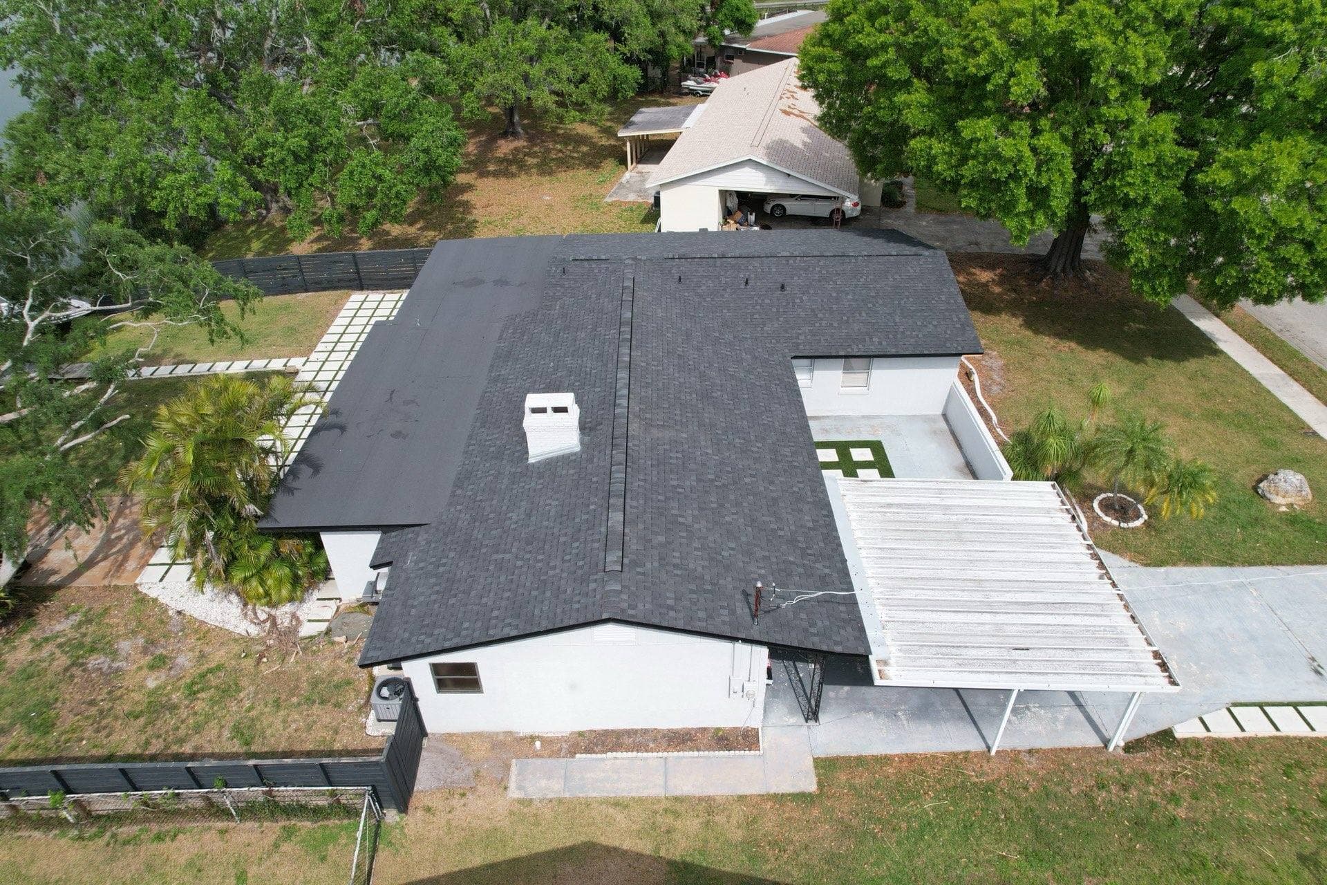 Aerial view of a completed dark gray architectural shingle roof replacement on a Tampa FL home