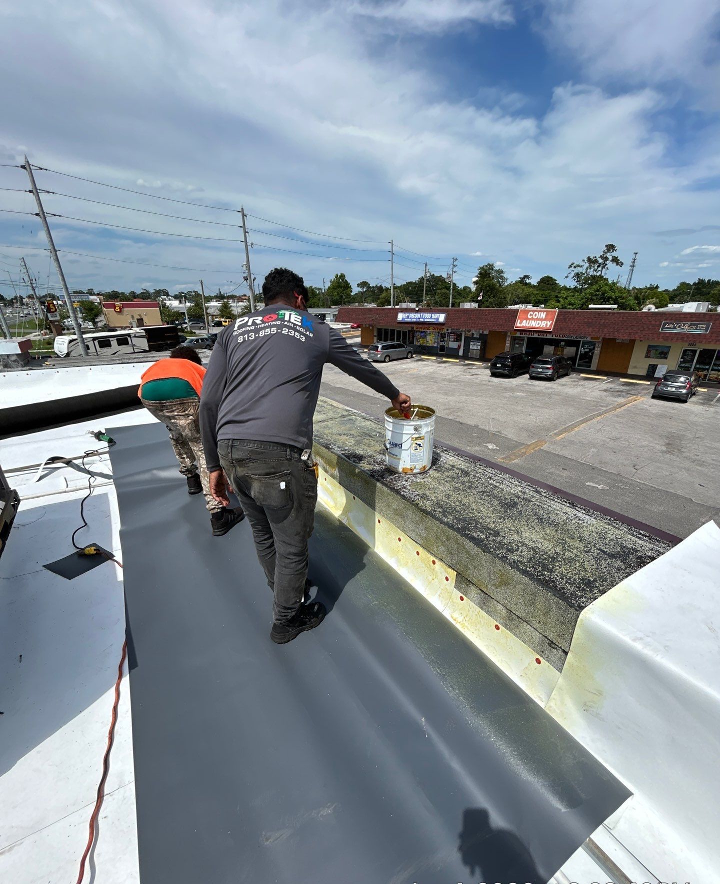 Protek crew sealing parapet flashing on a commercial flat roof in Dade City FL