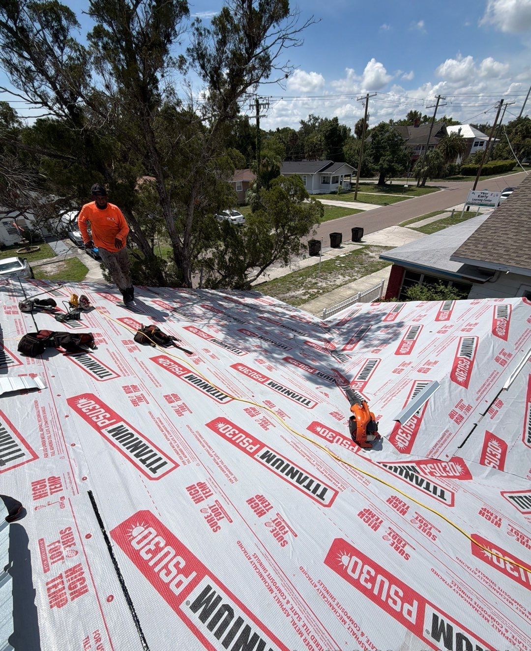 Protek crew installing Titanium PSU30 peel-and-stick underlayment on a Tampa FL roof