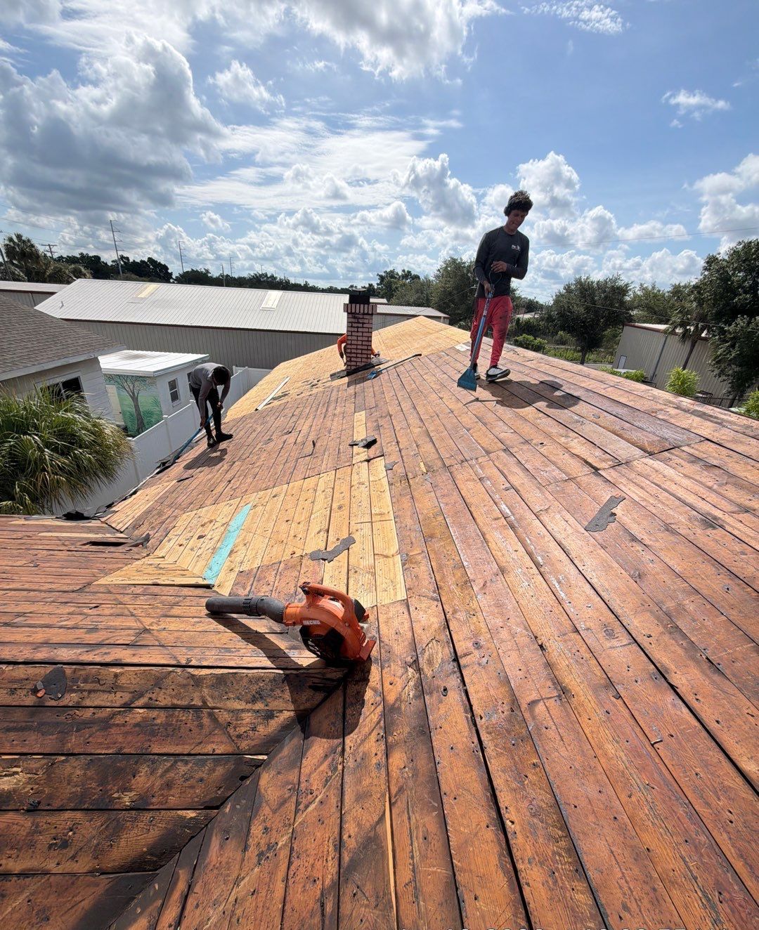 Protek crew on an exposed board deck during roof tear-off in Tampa FL