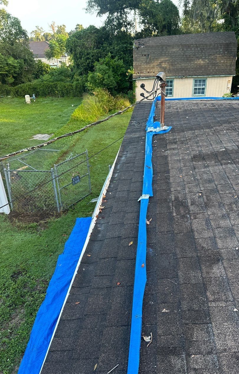 Old worn shingles and tarp strips on a Brandon roof