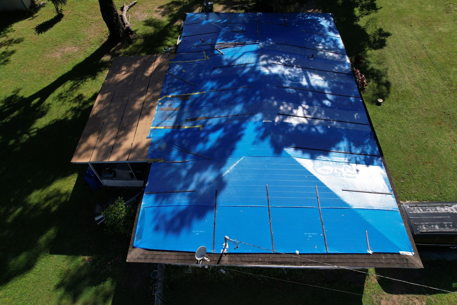 Aerial view of a storm-tarped roof in Brandon FL before metal replacement