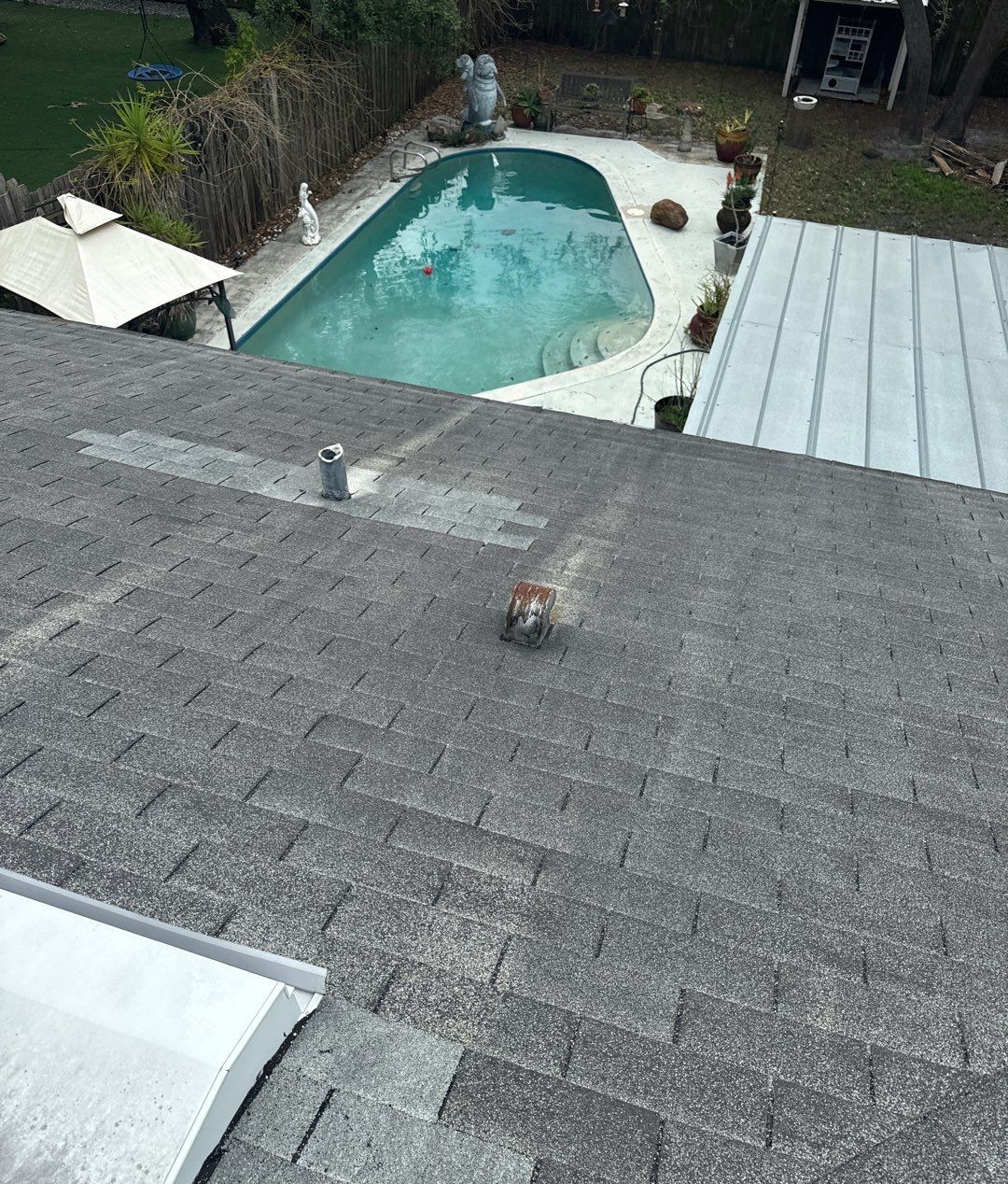 Worn shingles on the pool side of a South Tampa roof before replacement
