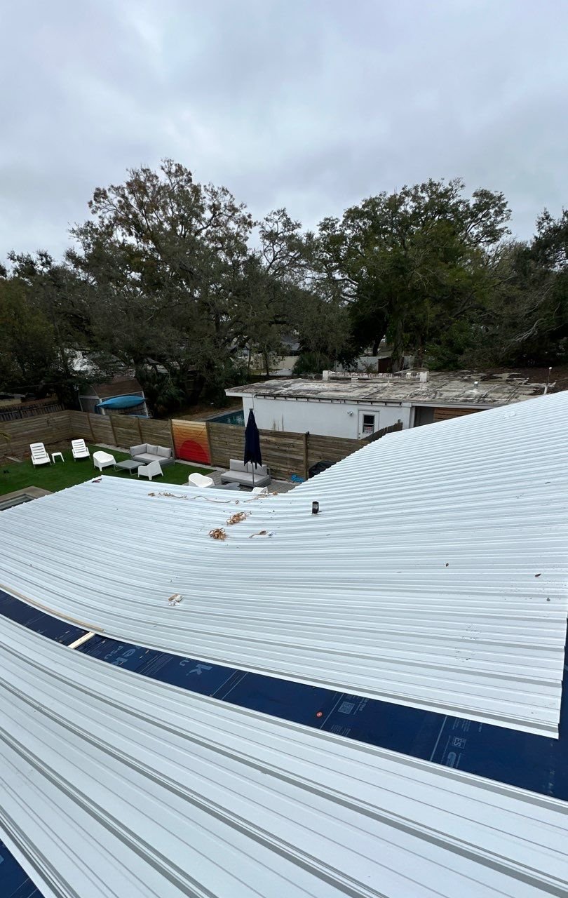 New white metal roof panels over the backyard after replacement in Tampa