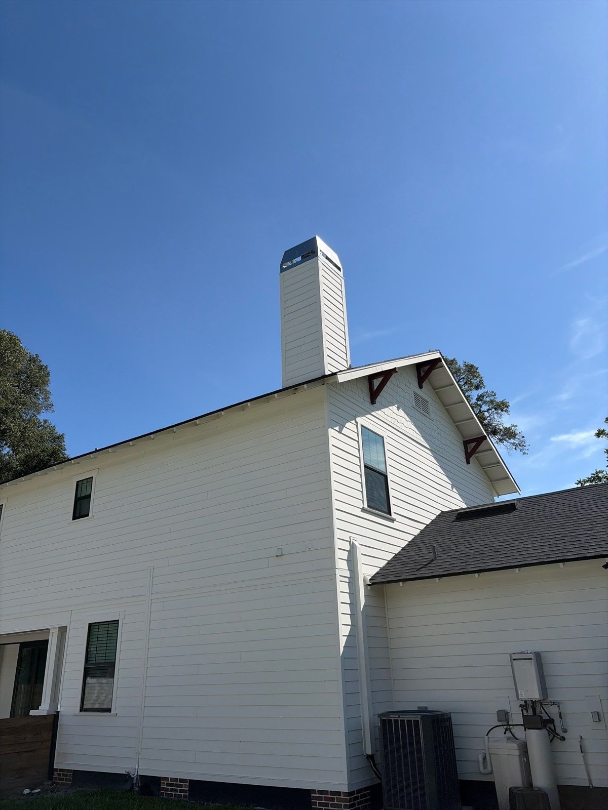 Rear elevation and chimney of a two-story Tampa FL home after roof repair