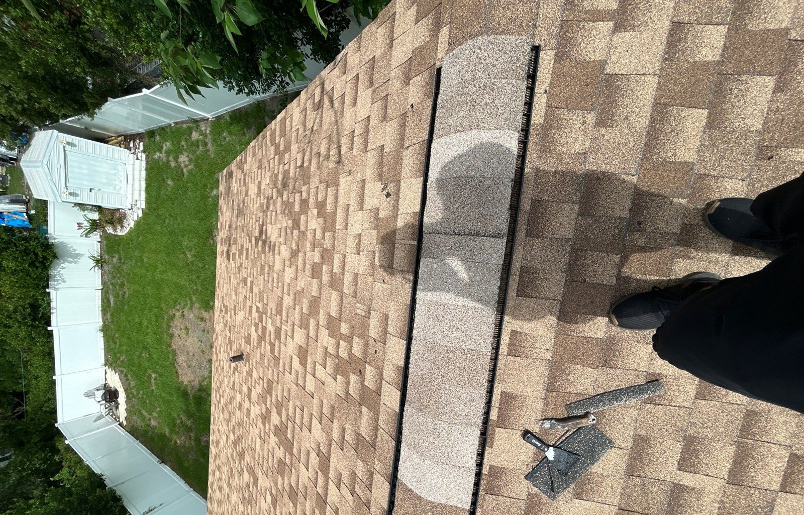 New ridge cap shingles installed over a ridge vent after wind damage repair in Tampa FL