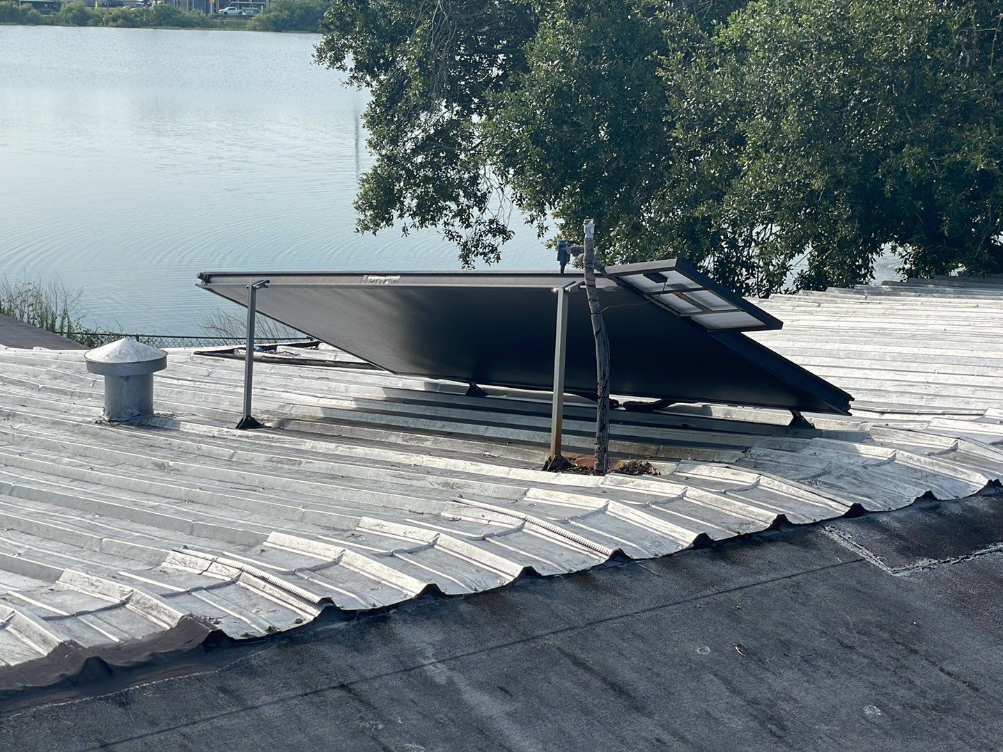 Old solar water heater panel on a metal roof before removal