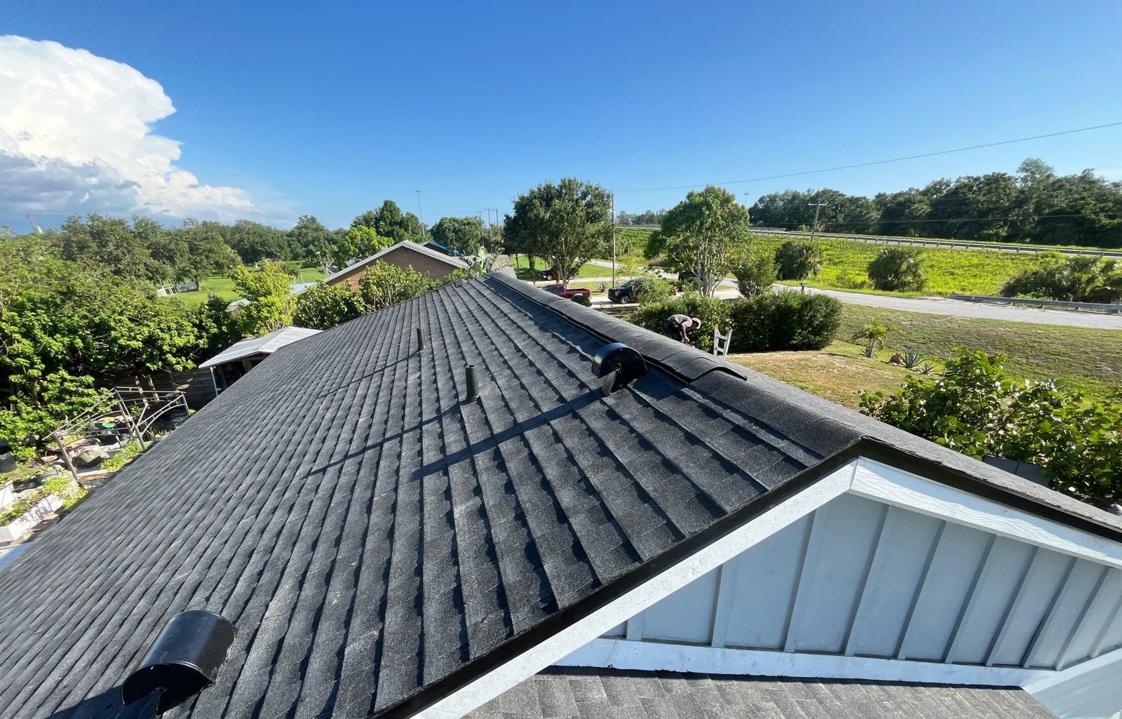 New black architectural shingle roof with white gable trim after replacement in Palmetto FL