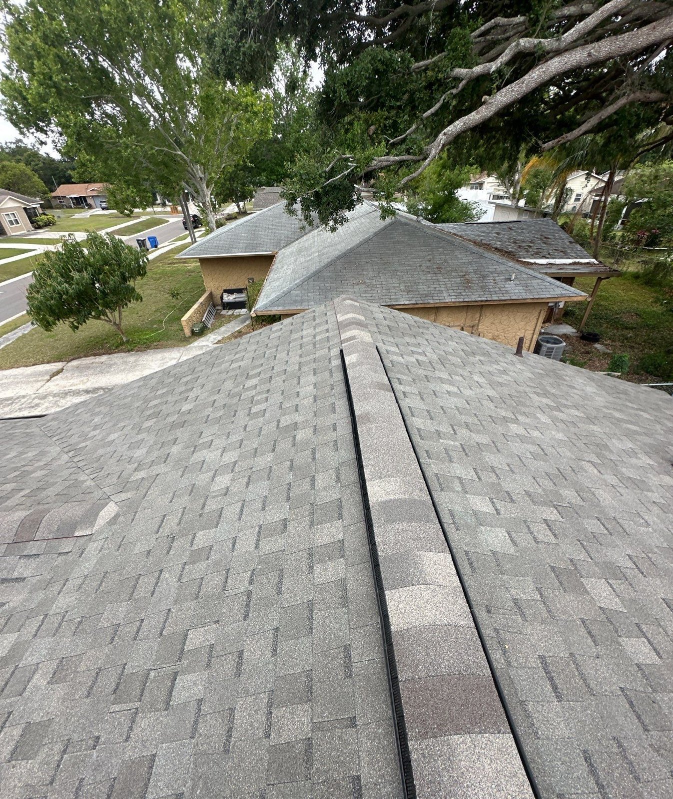 New gray architectural shingle roof with clean valleys after replacement in Seffner FL