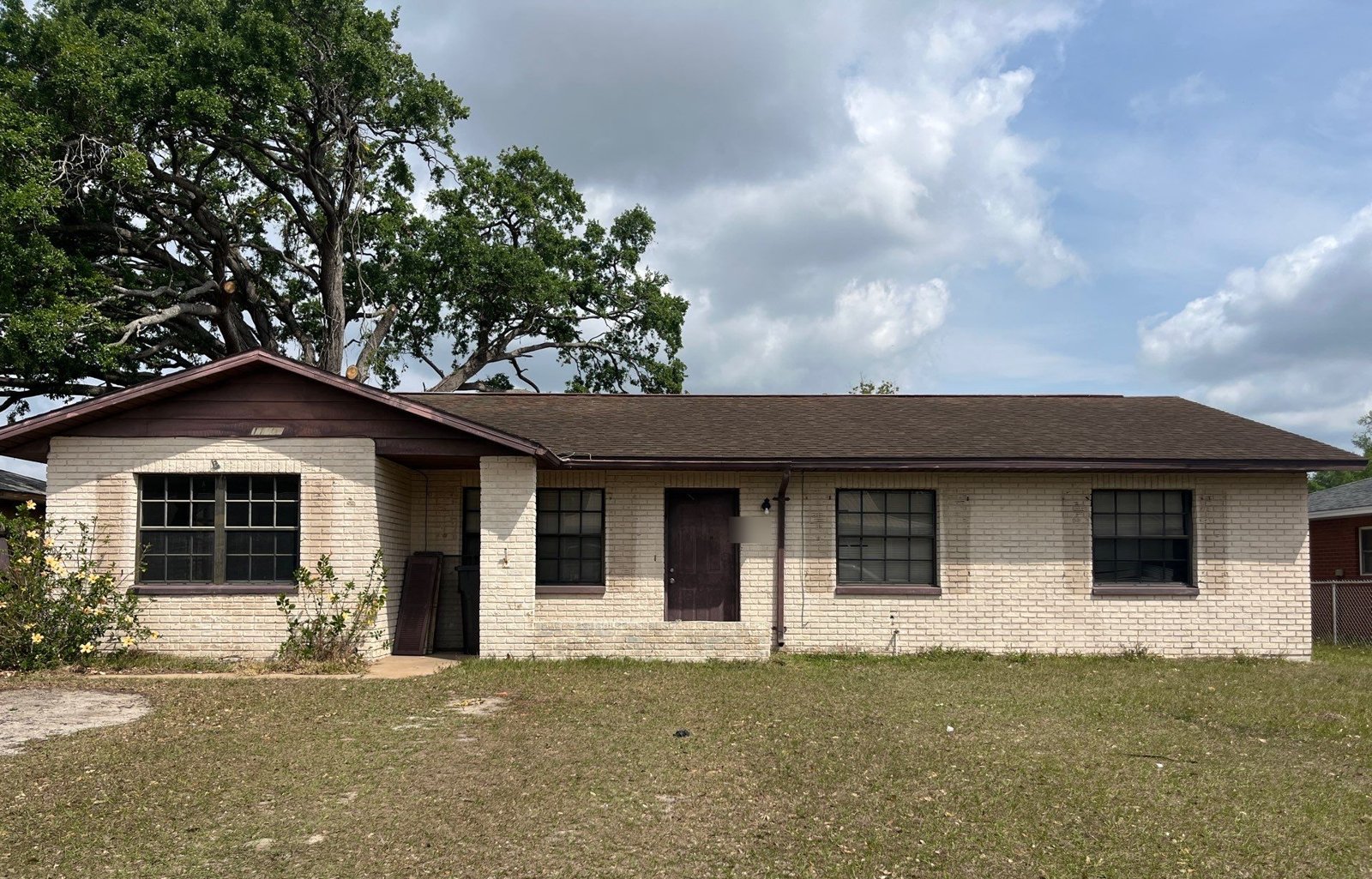 Brick ranch home with a worn brown shingle roof before replacement in Seffner FL