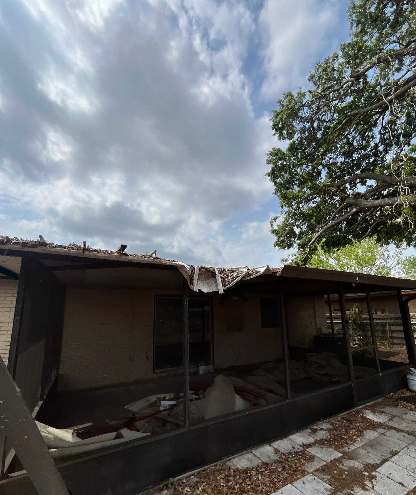 Rotted and collapsed roof overhang above a screened porch before roof replacement in Seffner FL