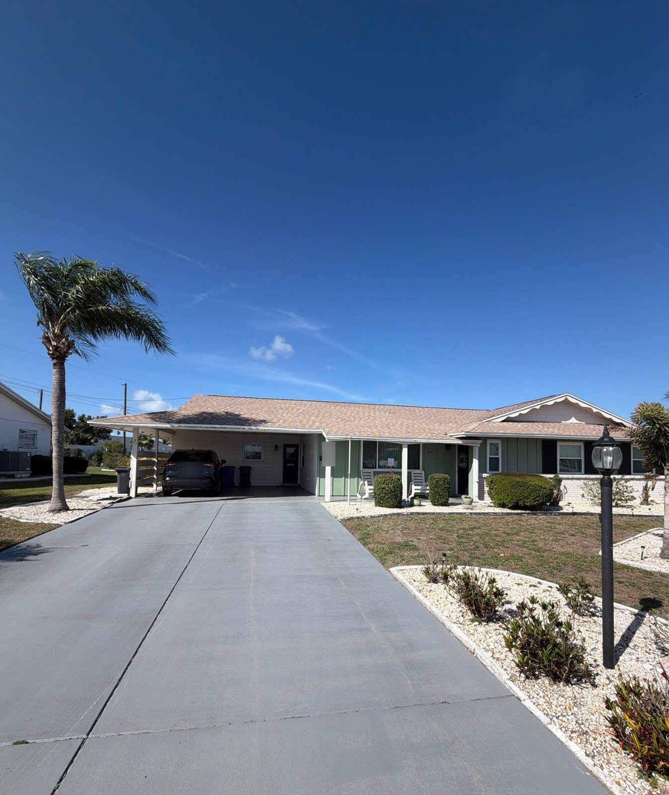 New light tan architectural shingle roof over the front elevation and carport in Sun City Center FL