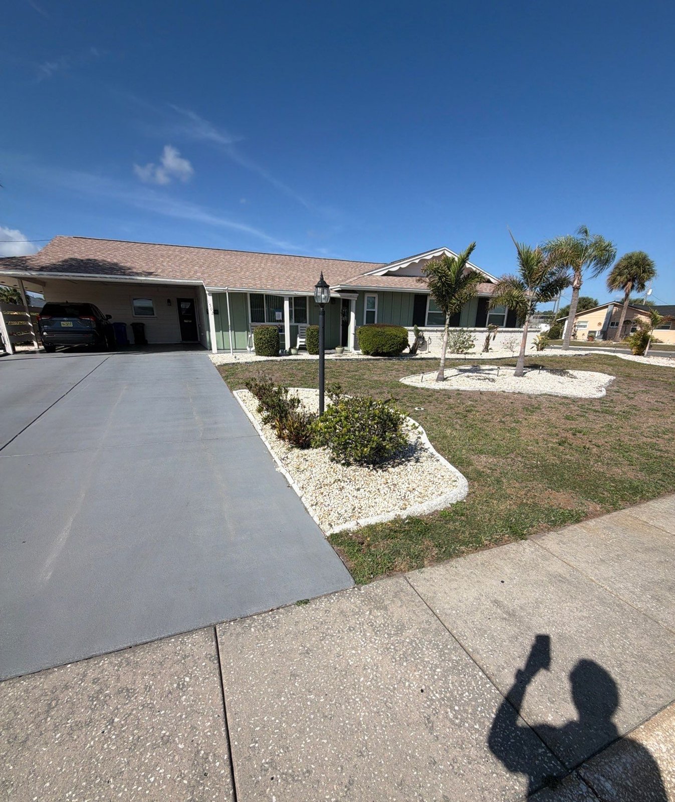 Finished light tan architectural shingle roof and gable from the yard in Sun City Center FL