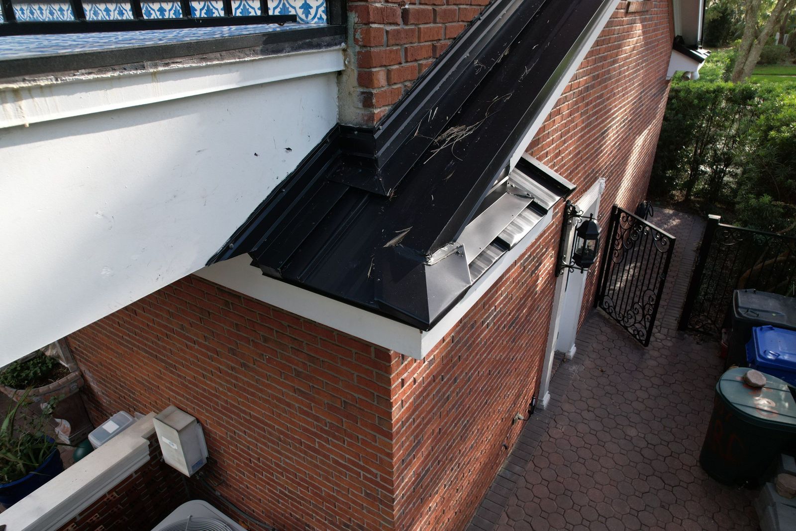 Standing seam metal roof section on the side of a brick home in Tampa