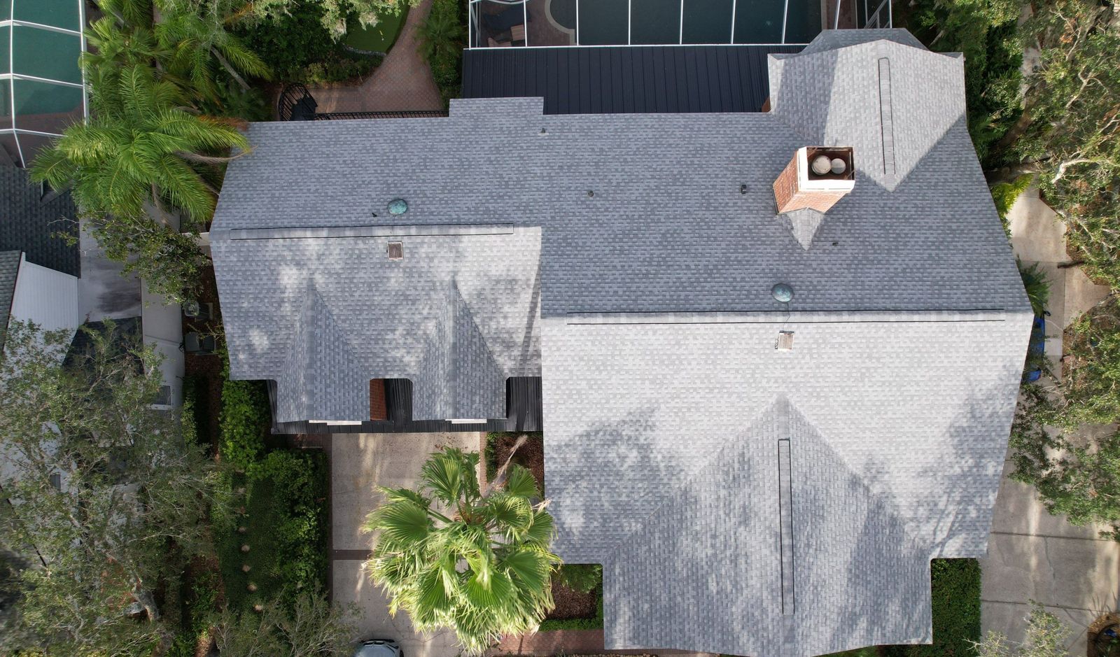 Top-down aerial of a Tampa home with shingle and standing seam metal roofing