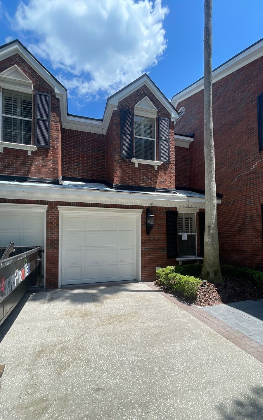 Front of a brick Tampa home with low roof sections before metal roofing